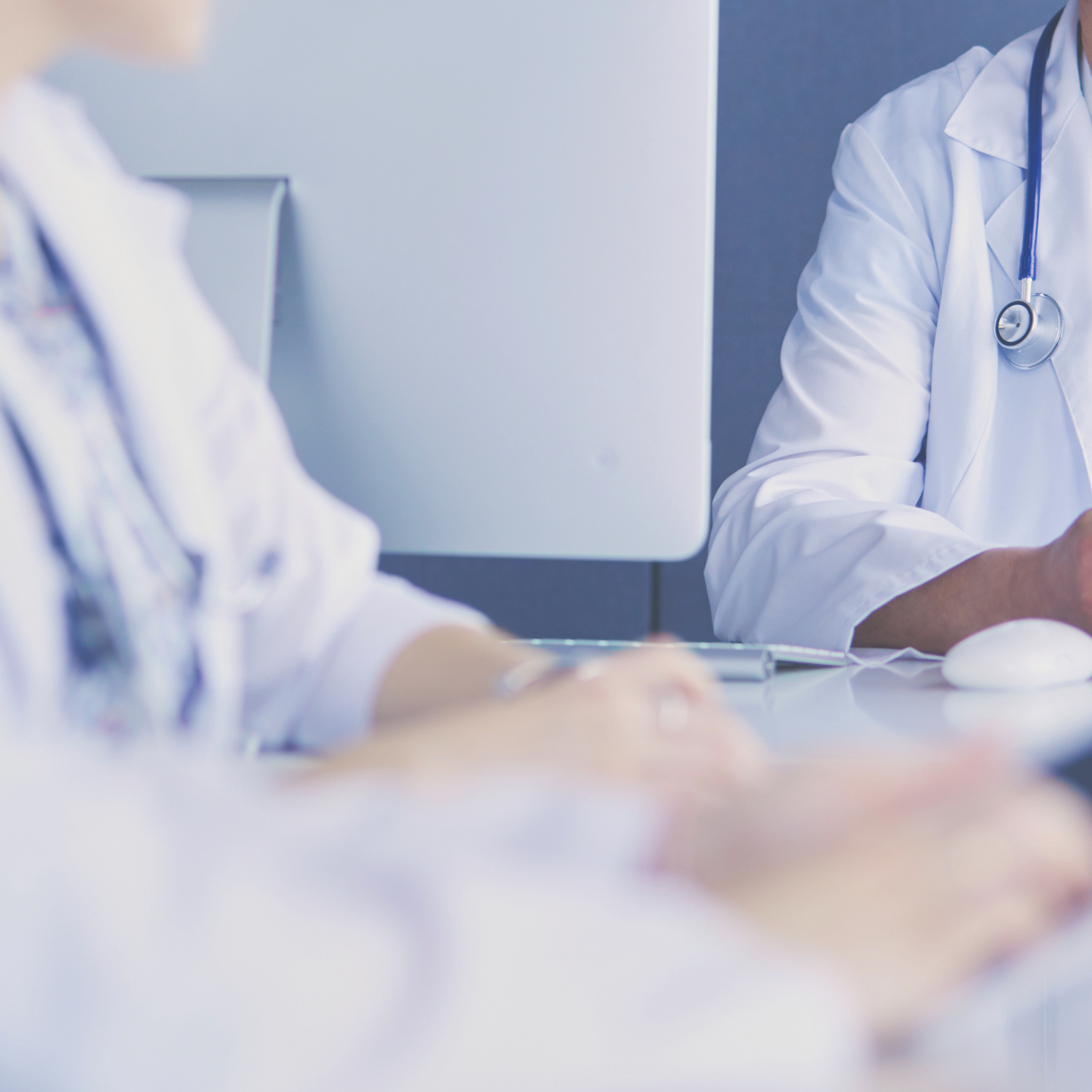 Serious medical team using a laptop in a bright office